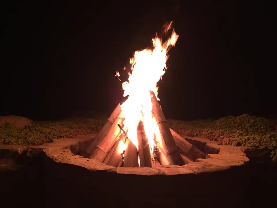Fogata encendida al aire libre por la noche.